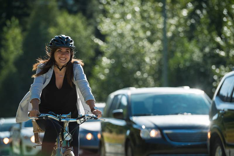 Photo of person riding bike in traffic.