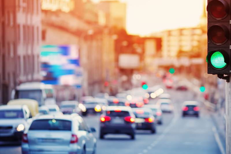 Photo of a stop light in a busy city.